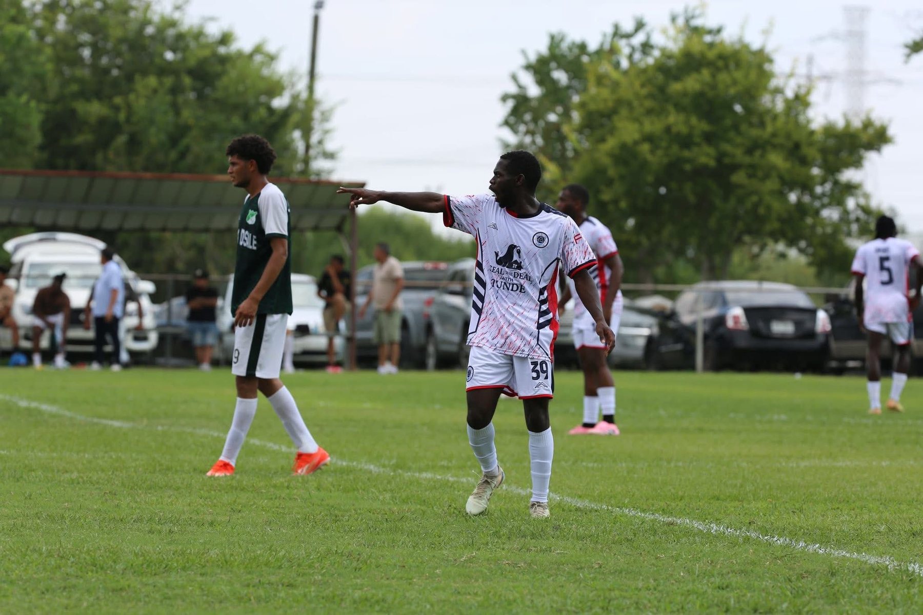 Player directing teammates during a community football match